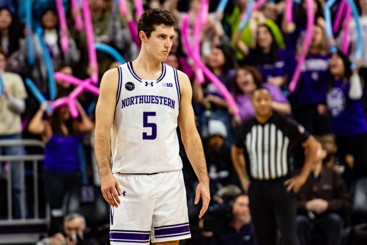 Northwestern’s Ryan Langborg stands in a white jersey, appearing frustrated.