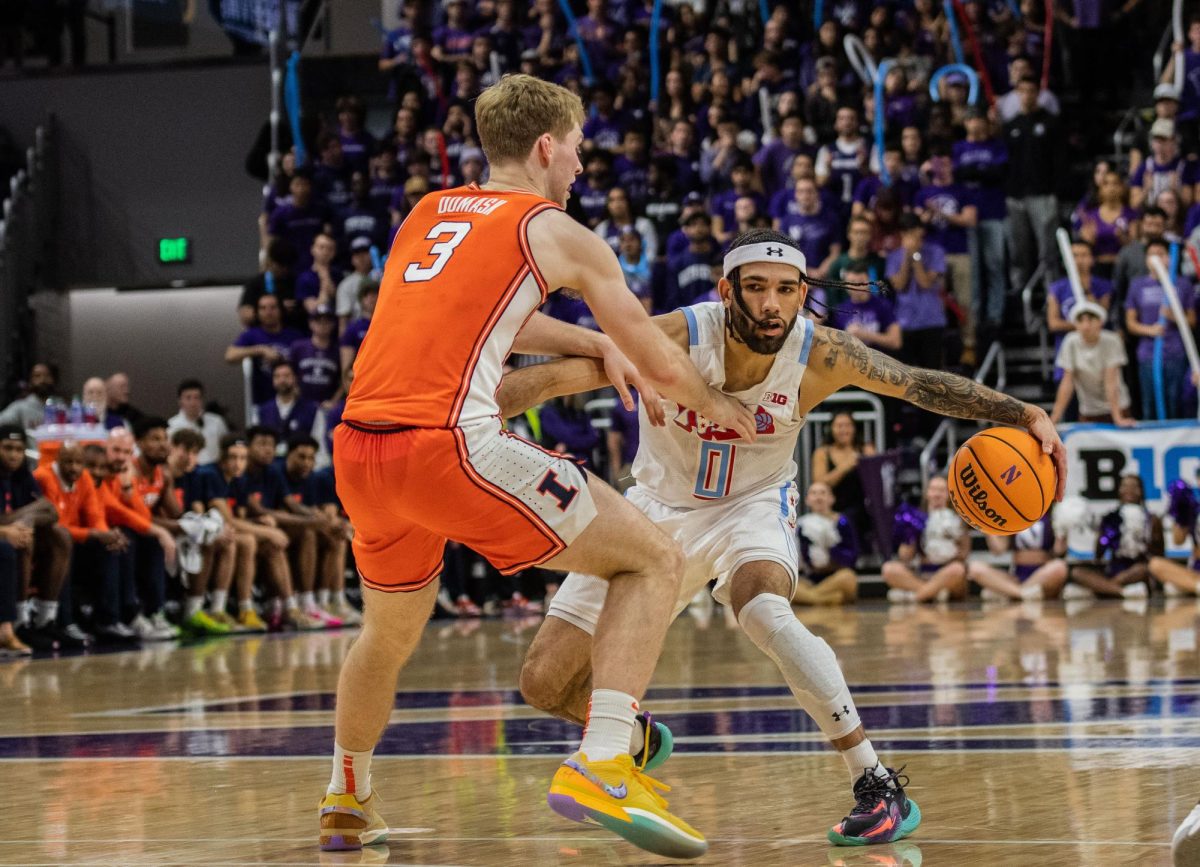 Boo Buie in a white uniform dribbles around a player in an orange uniform.