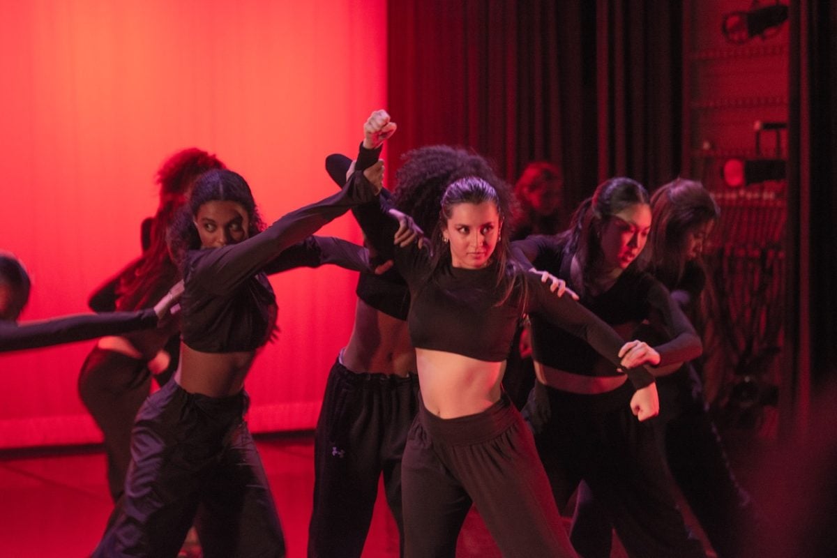 Dancers+dressed+in+all+black+create+a+powerful+formation+under+red+lighting.