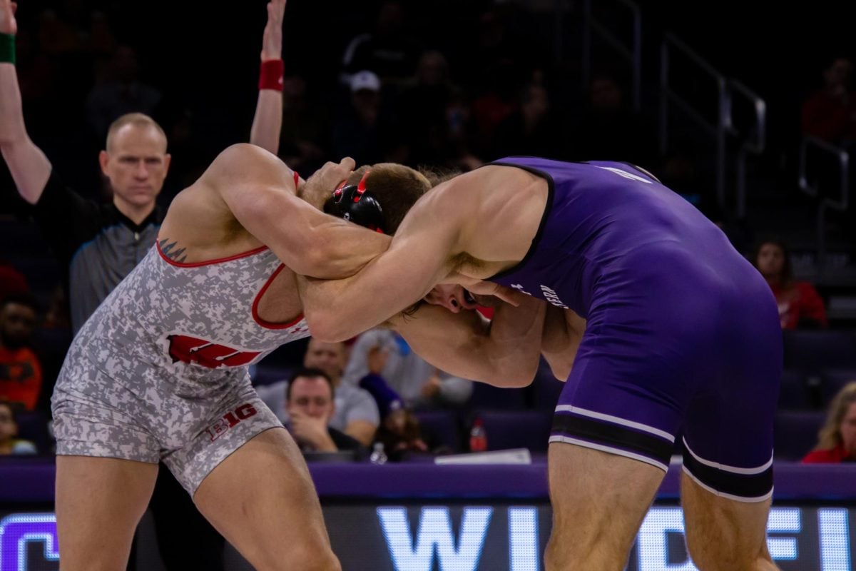 A Northwestern wrestler commences a match against a Wisconsin wrestler in the neutral position. The team is set to wrestle the Badgers again this season on Feb. 2.