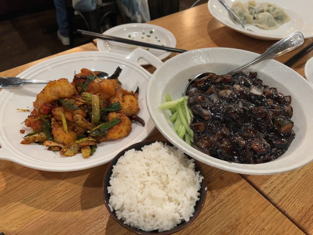 Three bowls of white rice, spicy chili shrimp and cha jang mein sit on a wooden table.