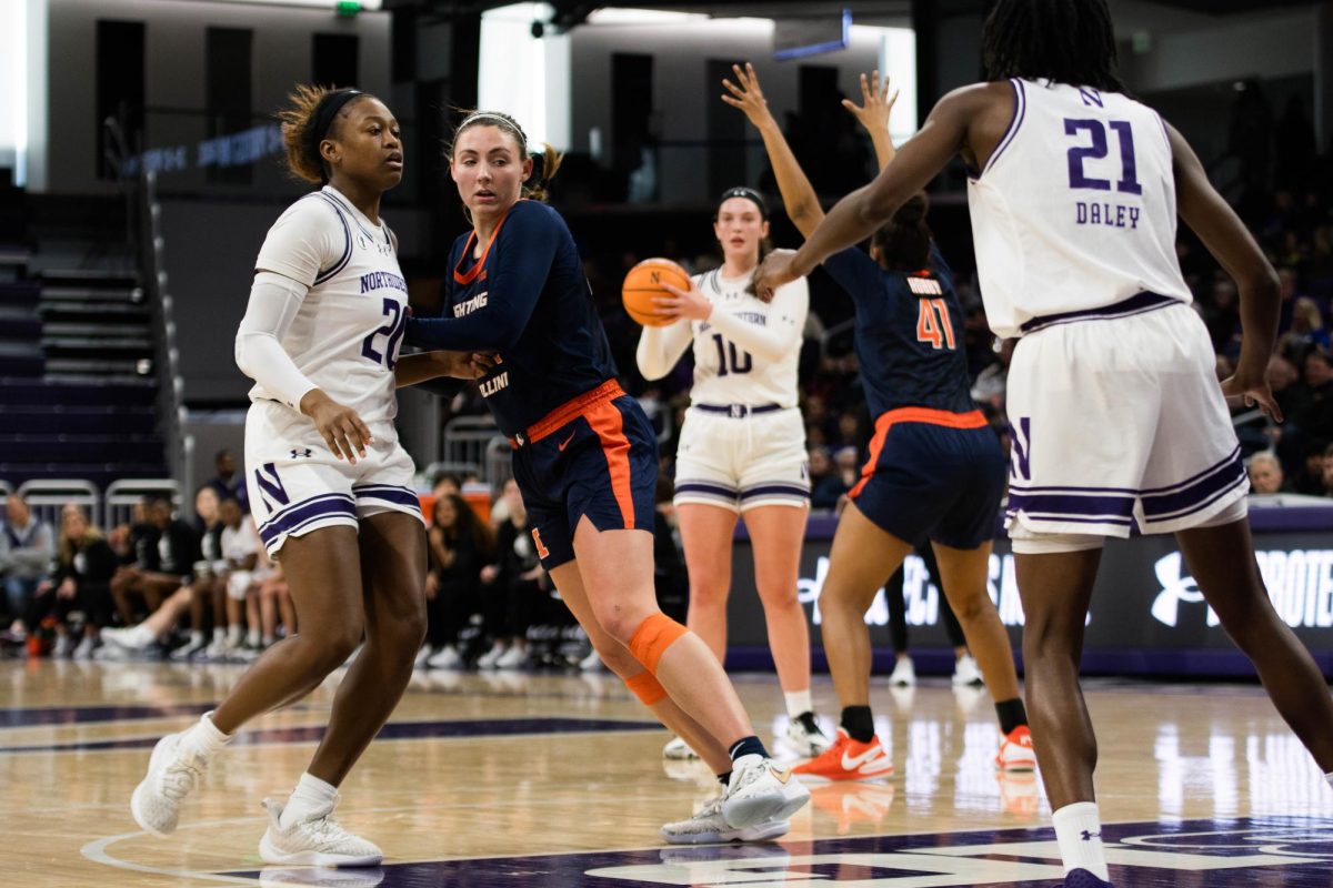 Northwestern’s Caileigh Walsh looks for a teammate to pass the ball to. A player wearing dark blue tries to block the shot.