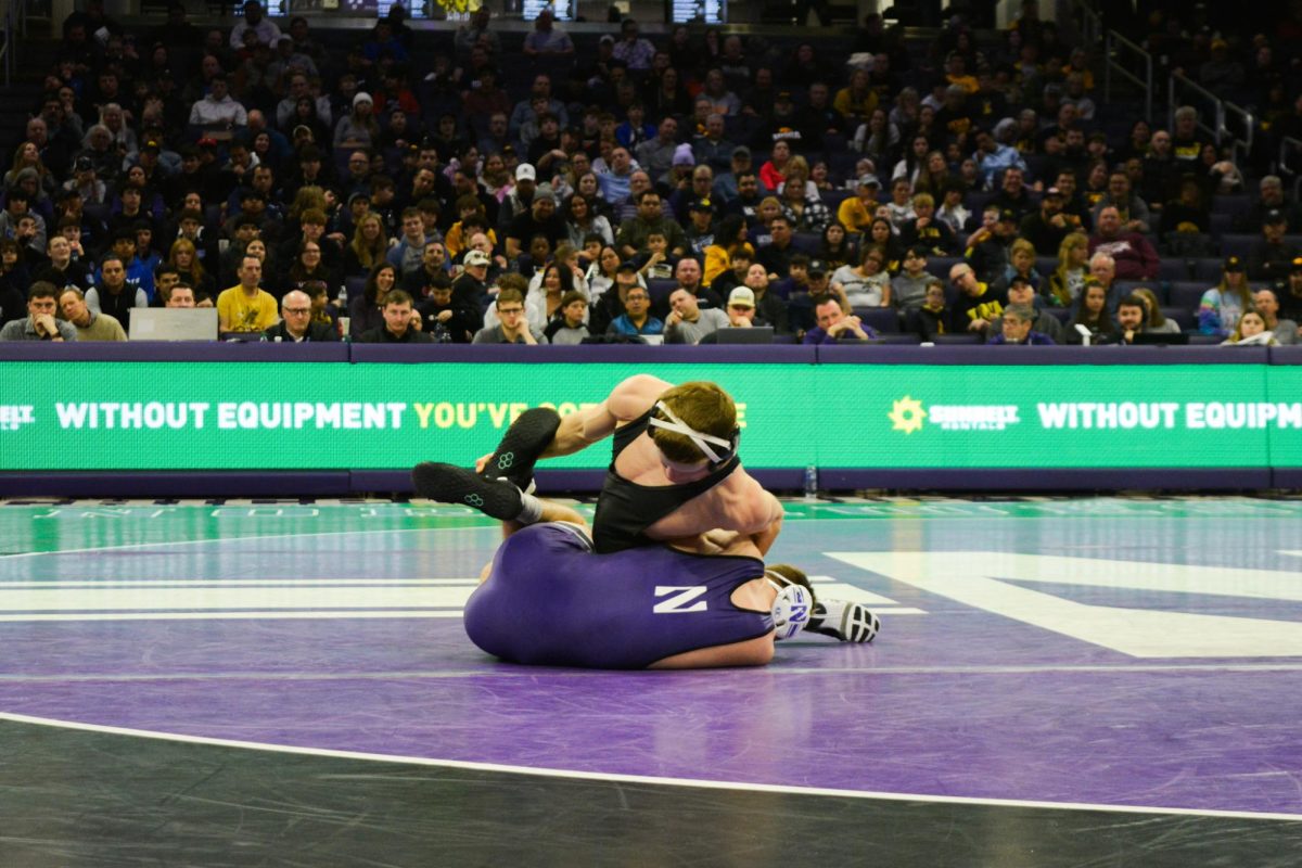 133-pounder Patrick Adams lies on the mat as his opponent attempts a pinning combination.
