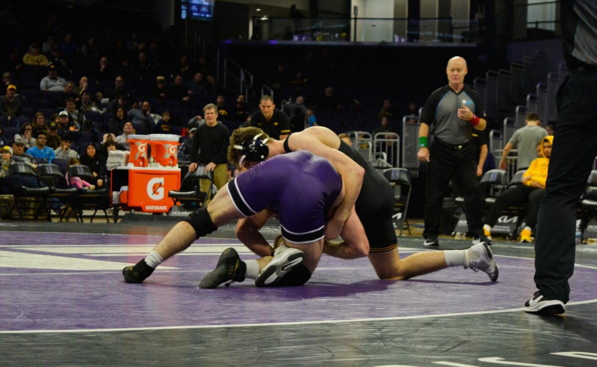 133-pounder Patrick Adams drives a shot forward as his opponent sprawls and wraps his arms around him.