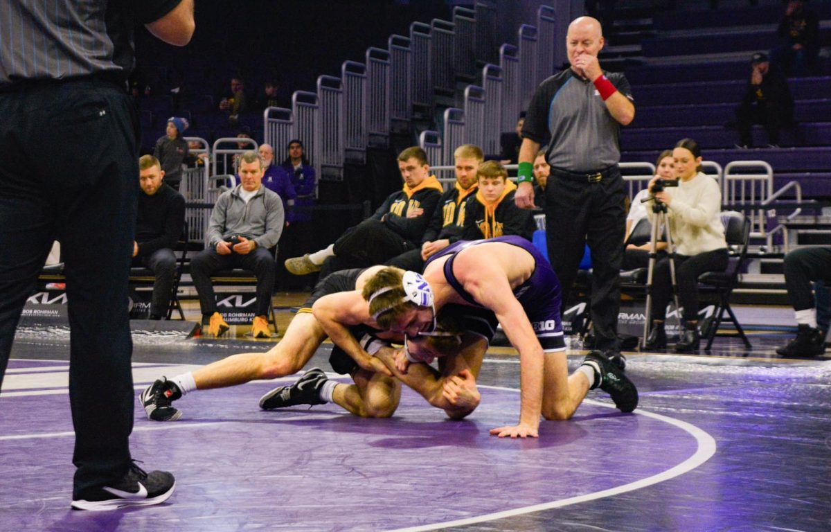 133-pounder Patrick Adams attempts a seatbelt whizzer as his opponent drives him towards the mat.