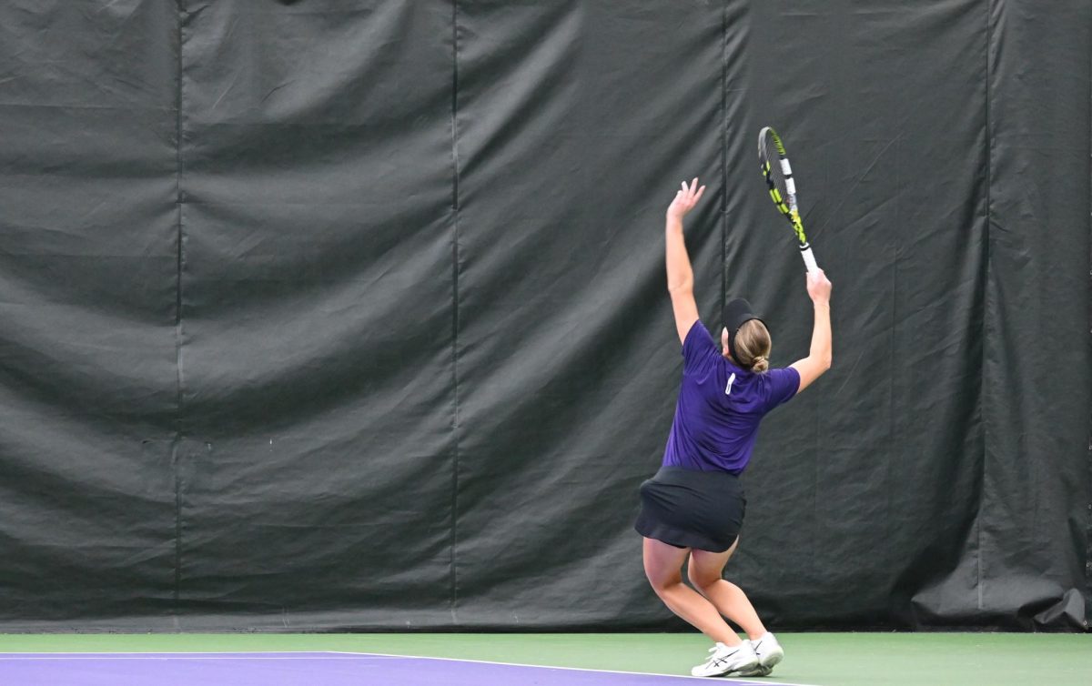 An NU Women’s Tennis player about to serve the ball.