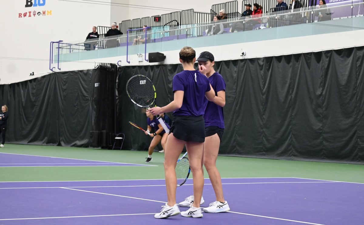 Two NU Women’s Tennis players celebrating after winning a point.