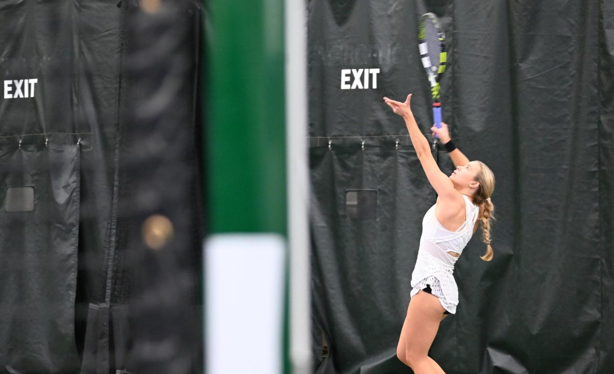 A Butler University Women’s Tennis player serving the ball.
