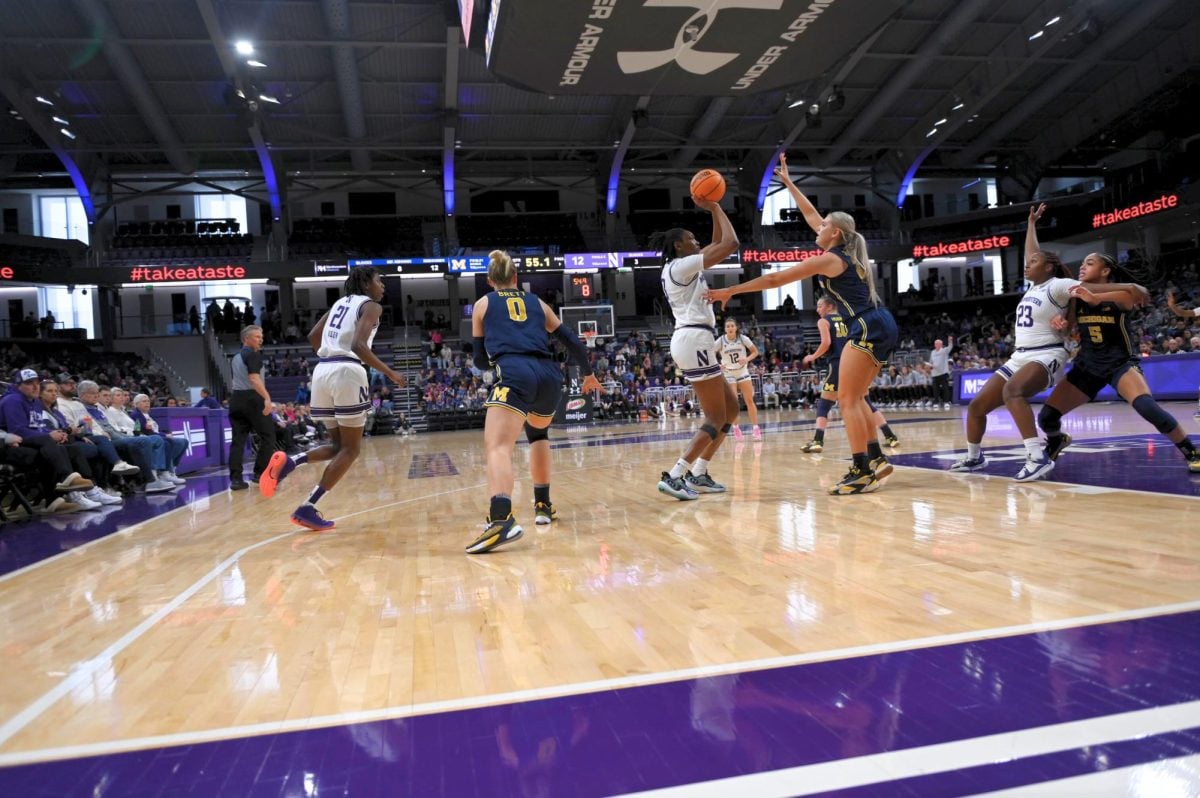 Mercy Ademusayo shoots the basketball with a Michigan player on defense.