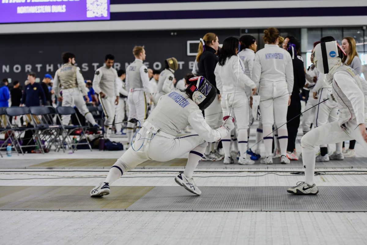 A Northwestern fencer wearing white and a black mask lunges at an athlete wearing white.