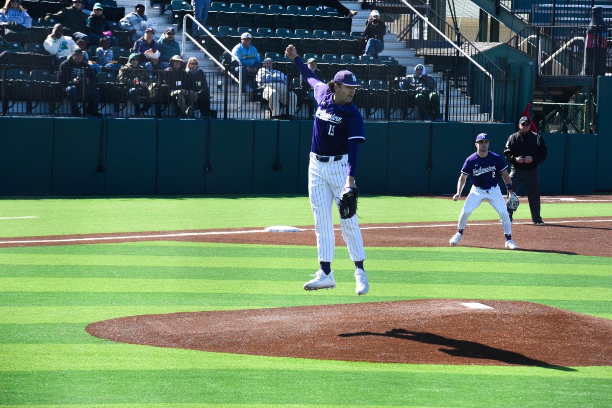 A Northwestern baseball player wearing purple jumps.