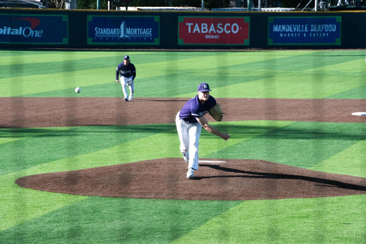 A Northwestern baseball player wearing purple pitches a baseball. 