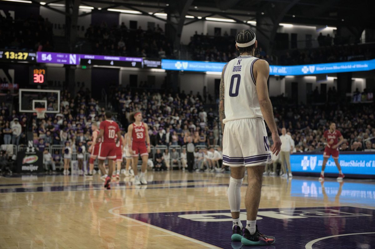 Northwestern’s Boo Buie stands near the court’s free throw line, looking away from the camera.