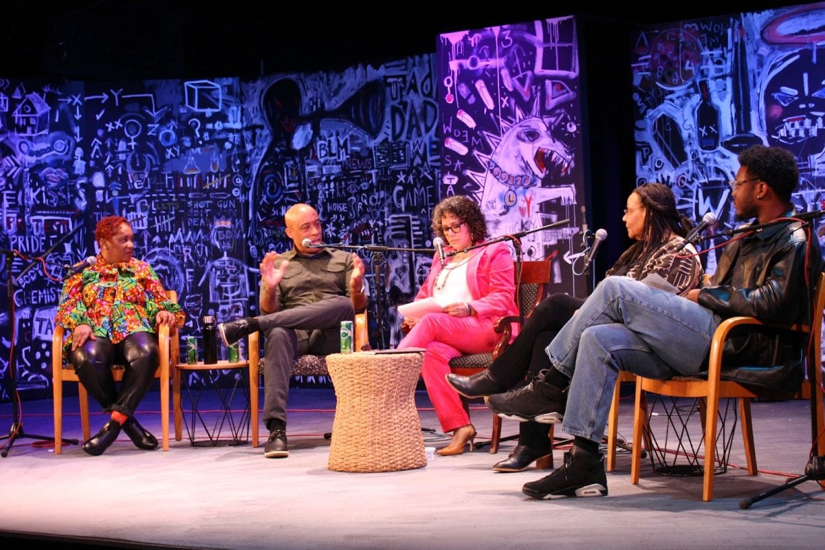 Five people sit on a stage for a panel discussion.