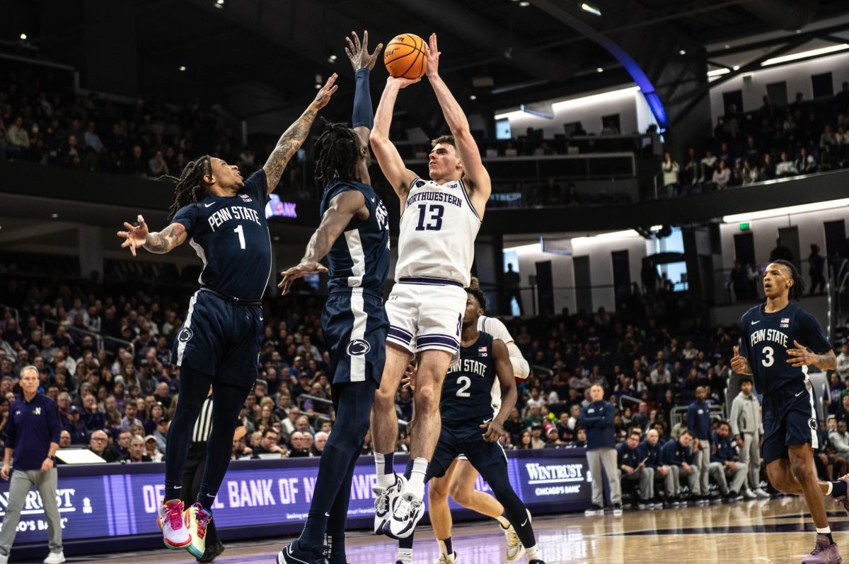 Junior guard Brooks Barnhizer shoots the ball as two Penn State defenders try to stop him. 