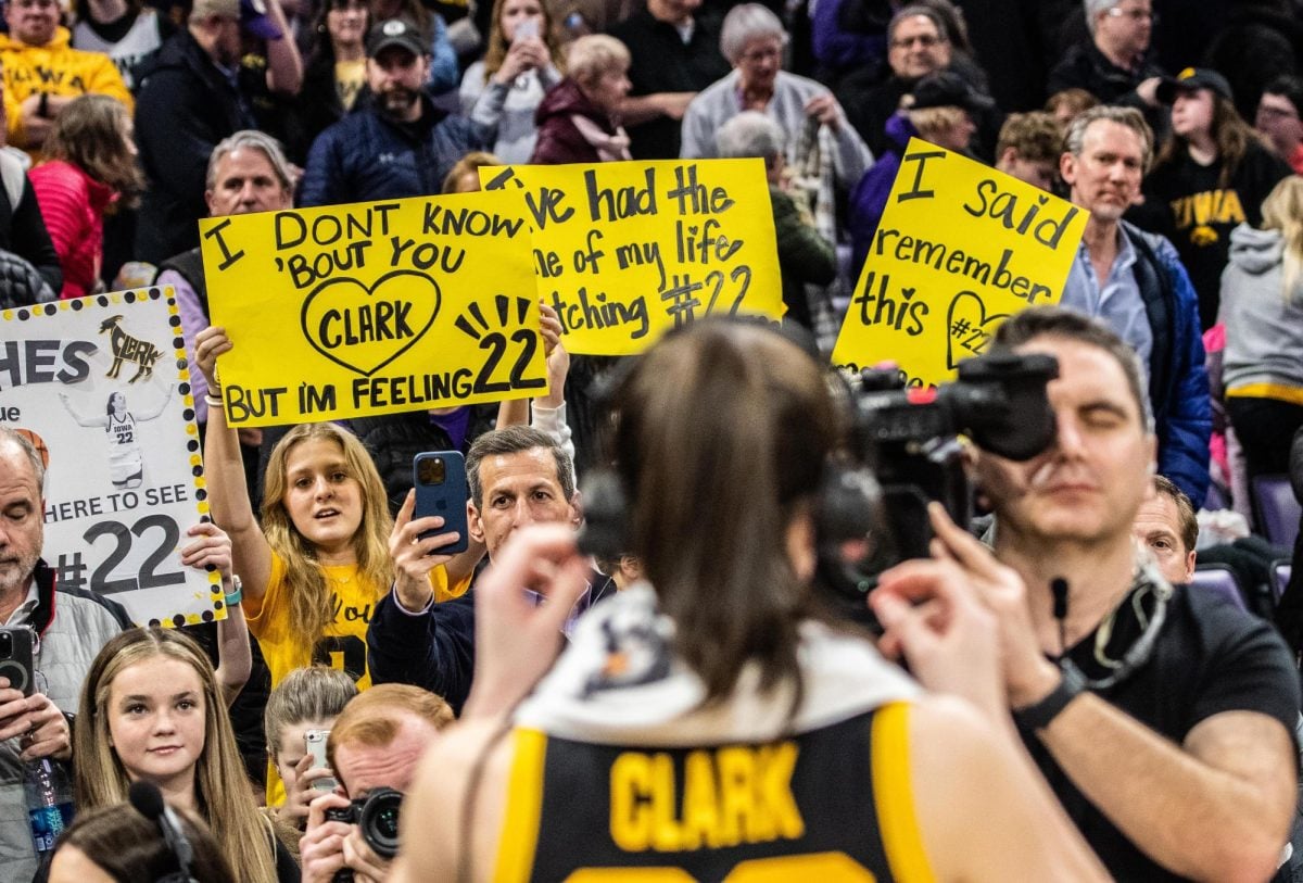 Fans hold up signs for Iowa’s Caitlin Clark as she takes a postgame interview. Welsh-Ryan Arena sold out for Wednesdays matchup between Northwestern and the Hawkeyes.