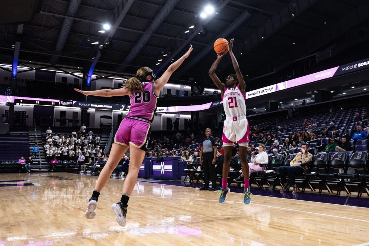 Northwestern’s Melannie Daley jumps, shooting the ball. An opponent tries to block.