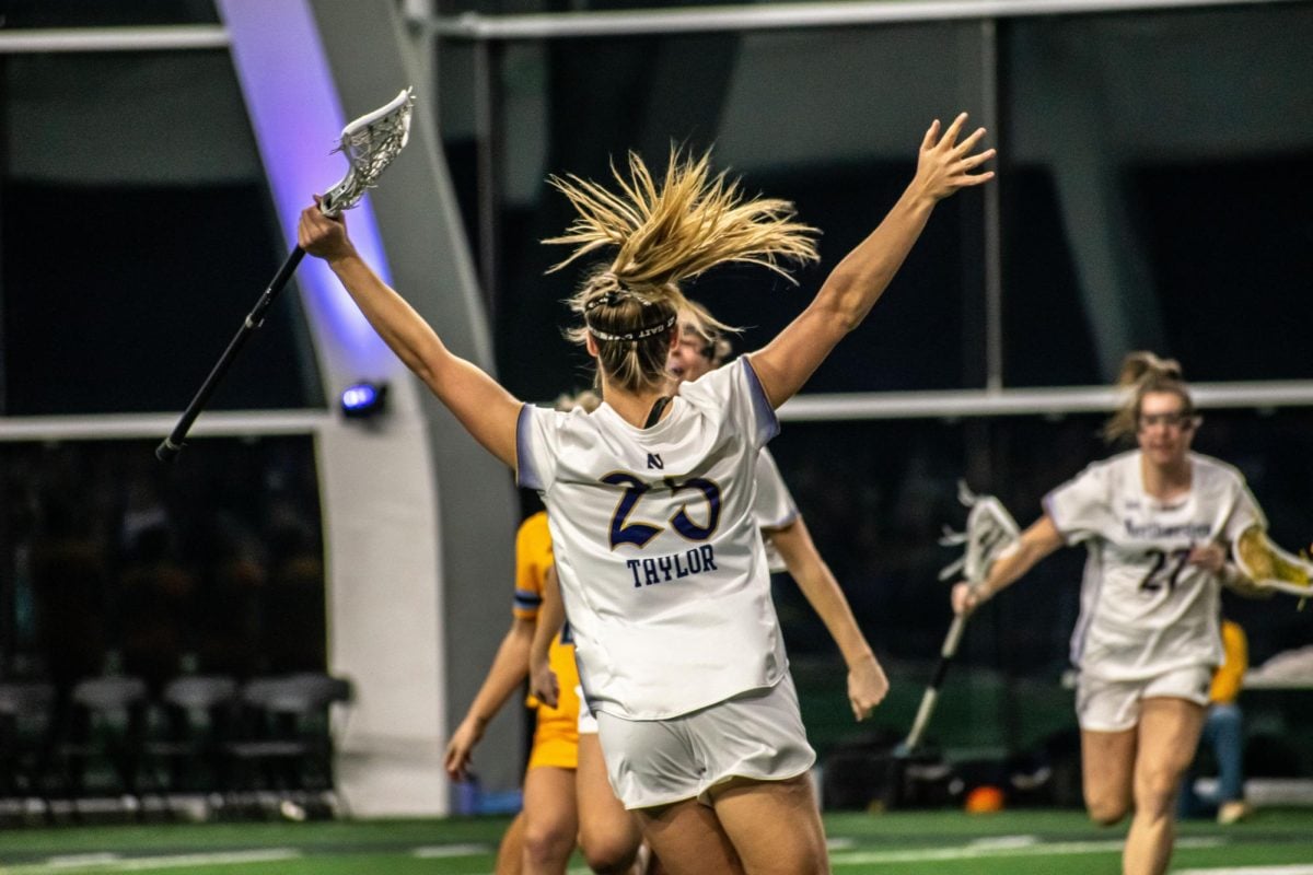 Northwestern’s Madison Taylor celebrates, her hands in the air and her back turned to the camera, after a goal.