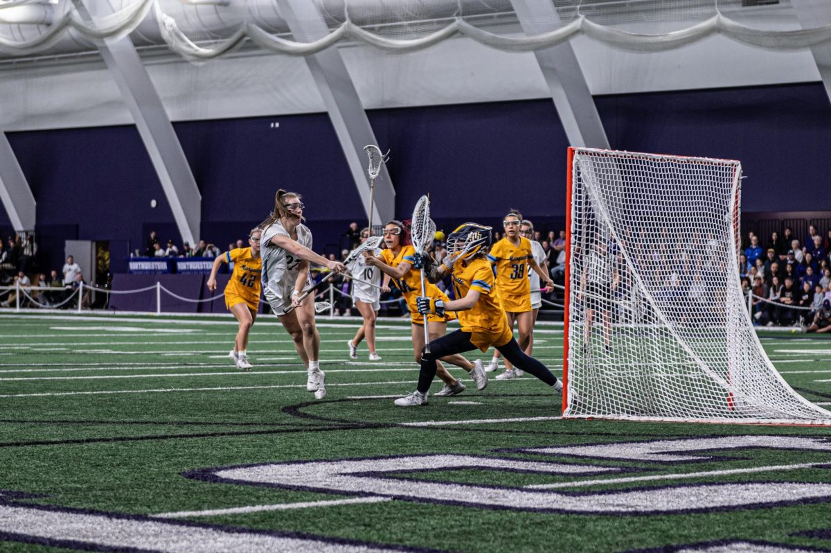 Northwestern’s Izzy Scane shoots the ball. The Marquette goalie, in yellow, tries to stop the shot, though she is unsuccessful.