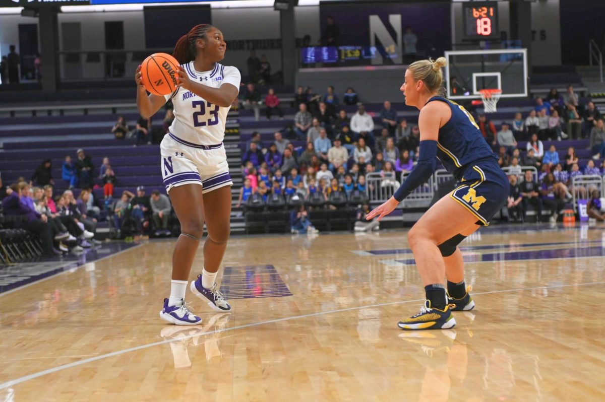 Jasmine McWilliams holds a basketball near the three-point line.
