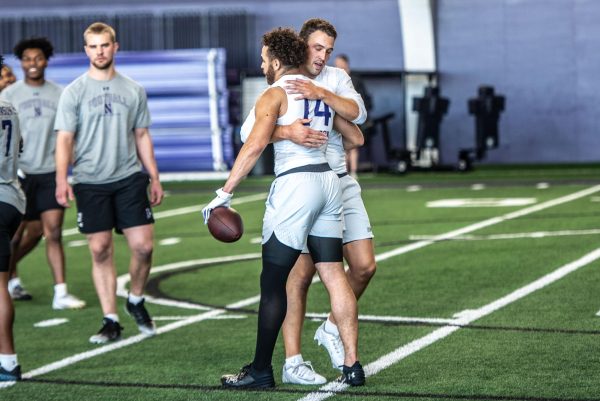 Northwestern quarterback Ben Bryant hugs receiver Cam Johnson at Wednesday’s Pro Day. Bryant, Johnson and linebacker Bryce Gallagher were NU’s three Pro Day participants.
