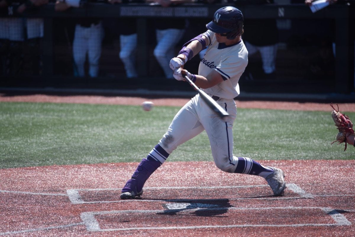 Northwestern baseball player mid-swing, about to make contact.
