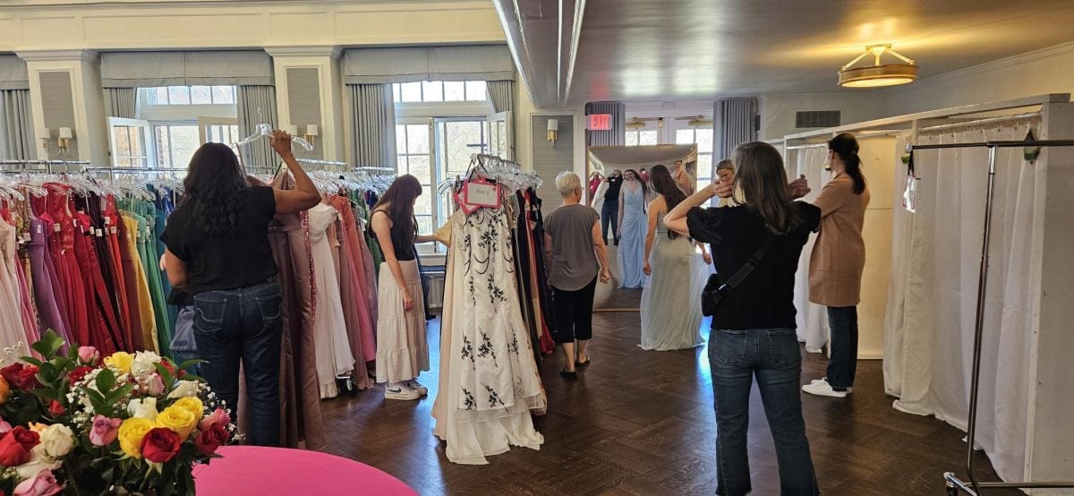 Students and volunteers pick out prom dresses.