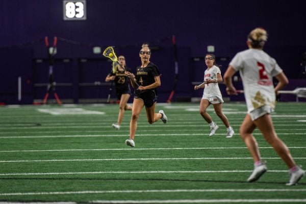 Graduate student defender Jane Hansen accelerates through the midfield in an early March matchup against Denver. Hansen tallied 26 ground balls and 23 caused turnovers in 15 regular season games.