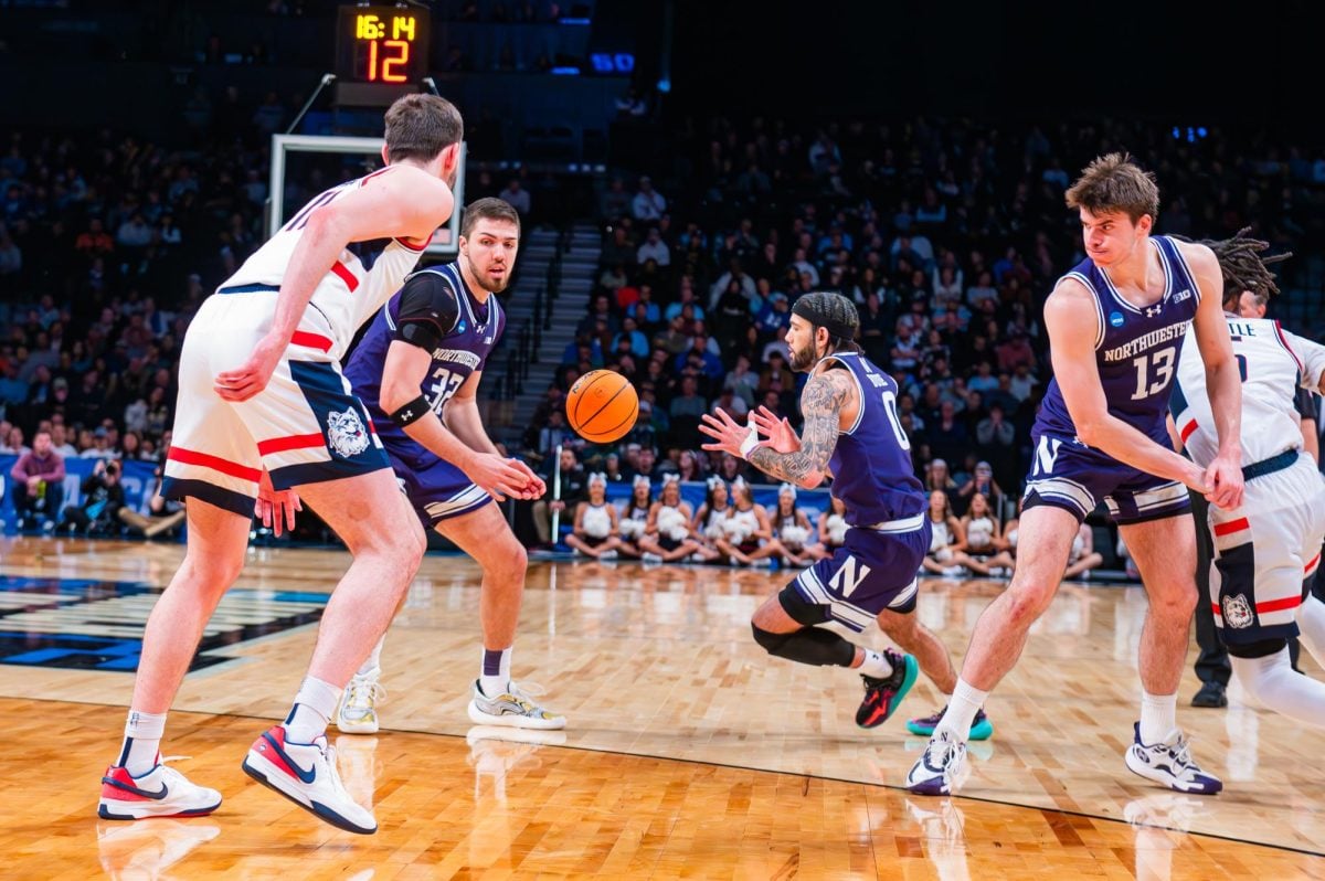 Basketball players in purple pass around the ball.