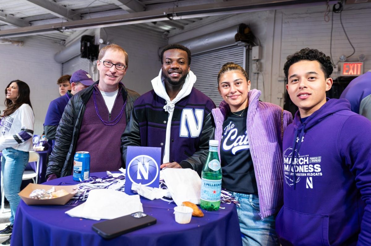 A former Northwestern basketball player and their friends pose for a photo.