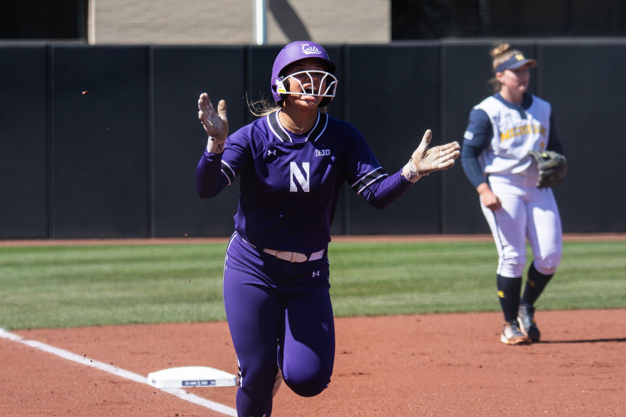 Northwestern sophomore infielder Kansas Robinson celebrates while circling the bases on a softball field.