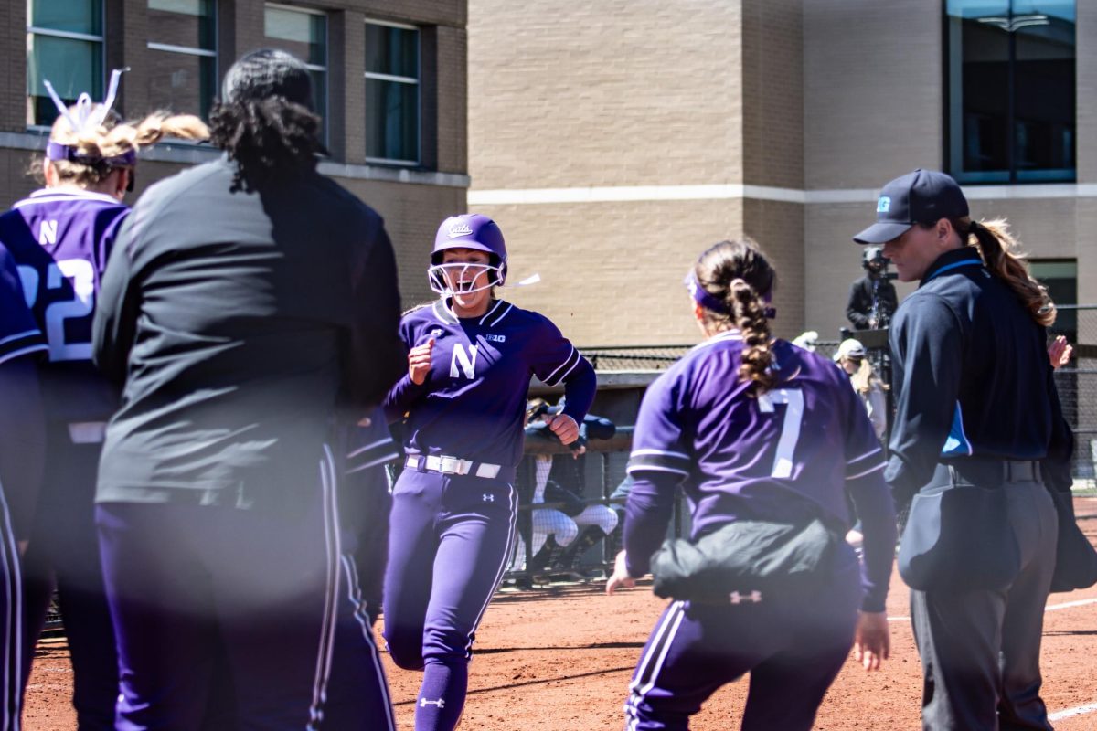 A Northwestern player celebrates after stepping on home plate during a home run.