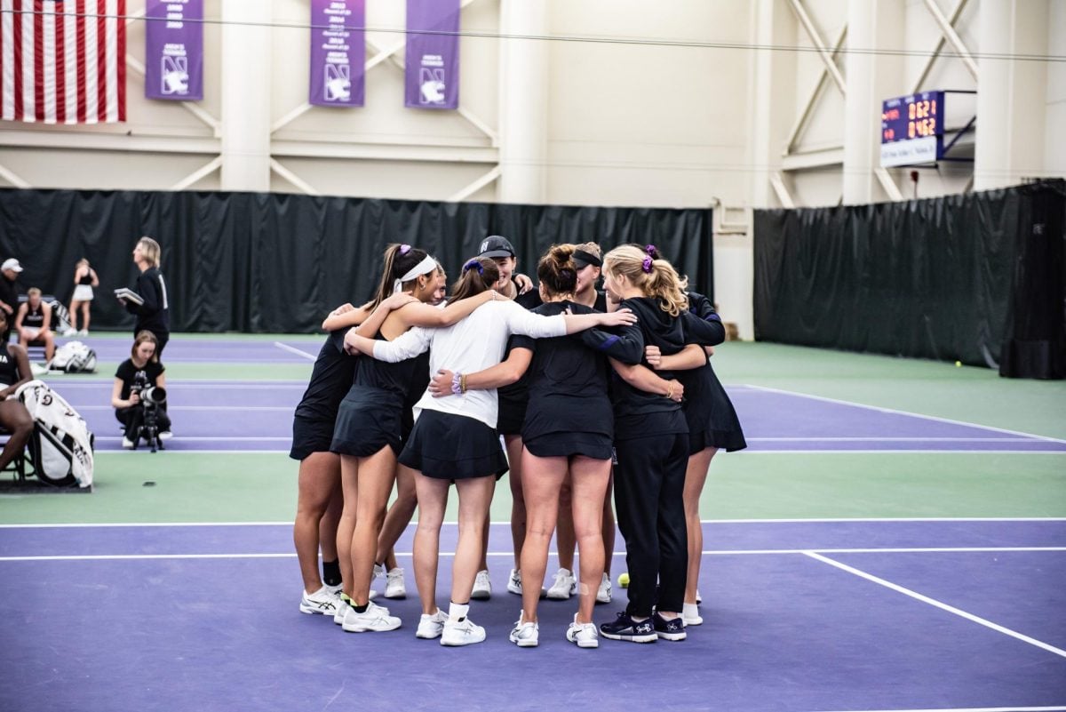 Northwestern huddles during Sunday’s Senior Day match. The ’Cats secured an 11-0 record at home this season.