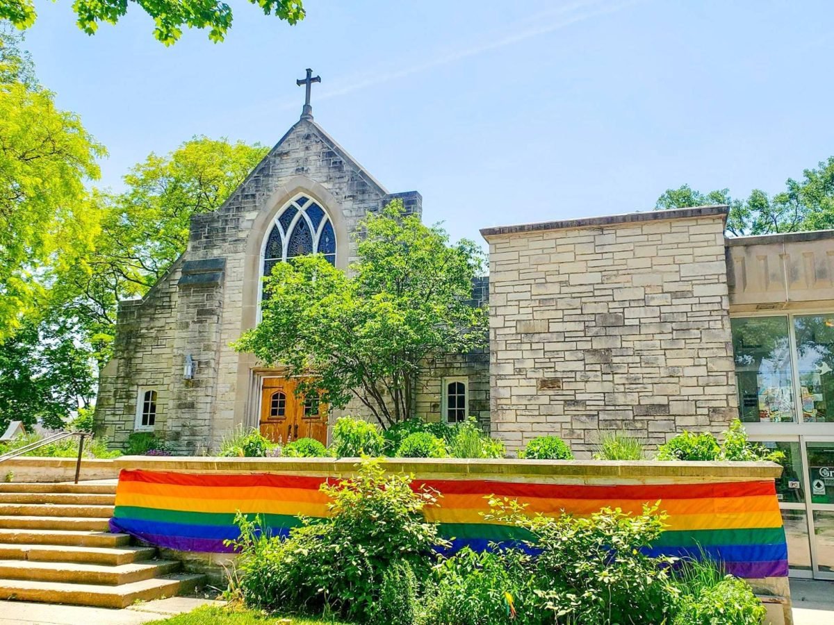 A Church with a rainbow flag in front.
