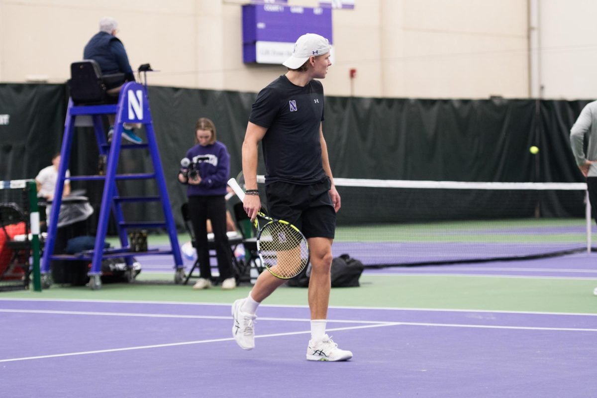 Junior Felix Nordby looks to the other side of the court holding a tennis racket. Nordby logged NU’s only singles victory against Indiana Friday.