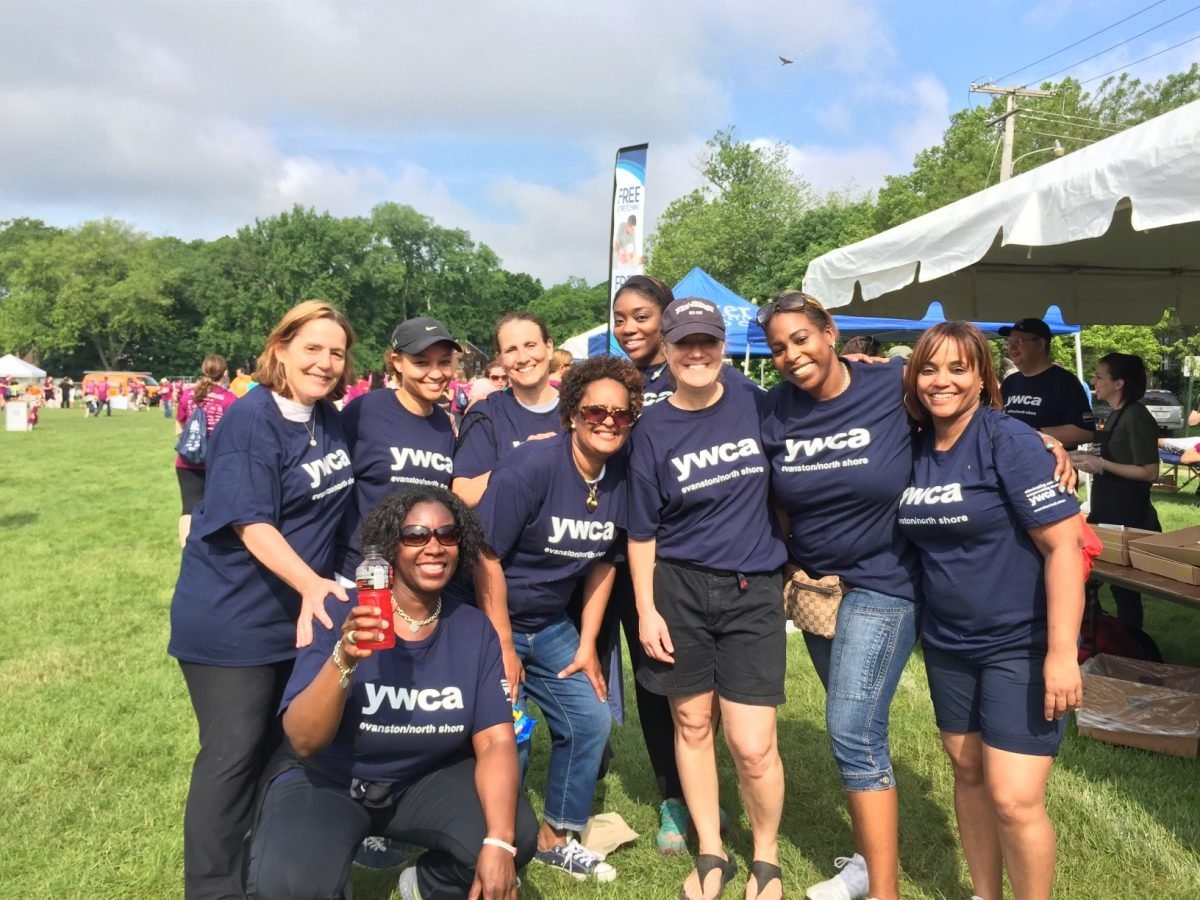 Nine volunteers pose for a photo at the 2015 Ricky Byrdsong Memorial Race Against Hate. All wear dark blue shirts that read “ywca evanston/north shore” in white font.