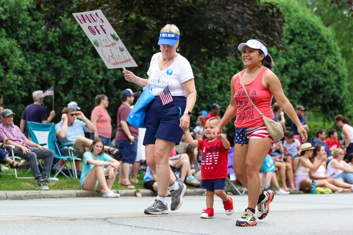 Parade-goers march with a “Hands off Our Bodies” sign.