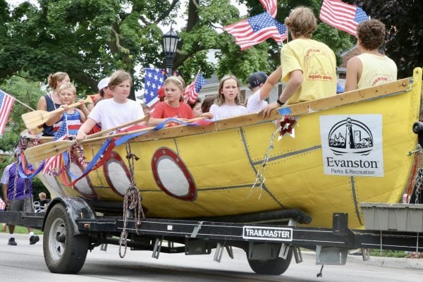 Children from Evanston Aquatic Camp ride in a parade float.