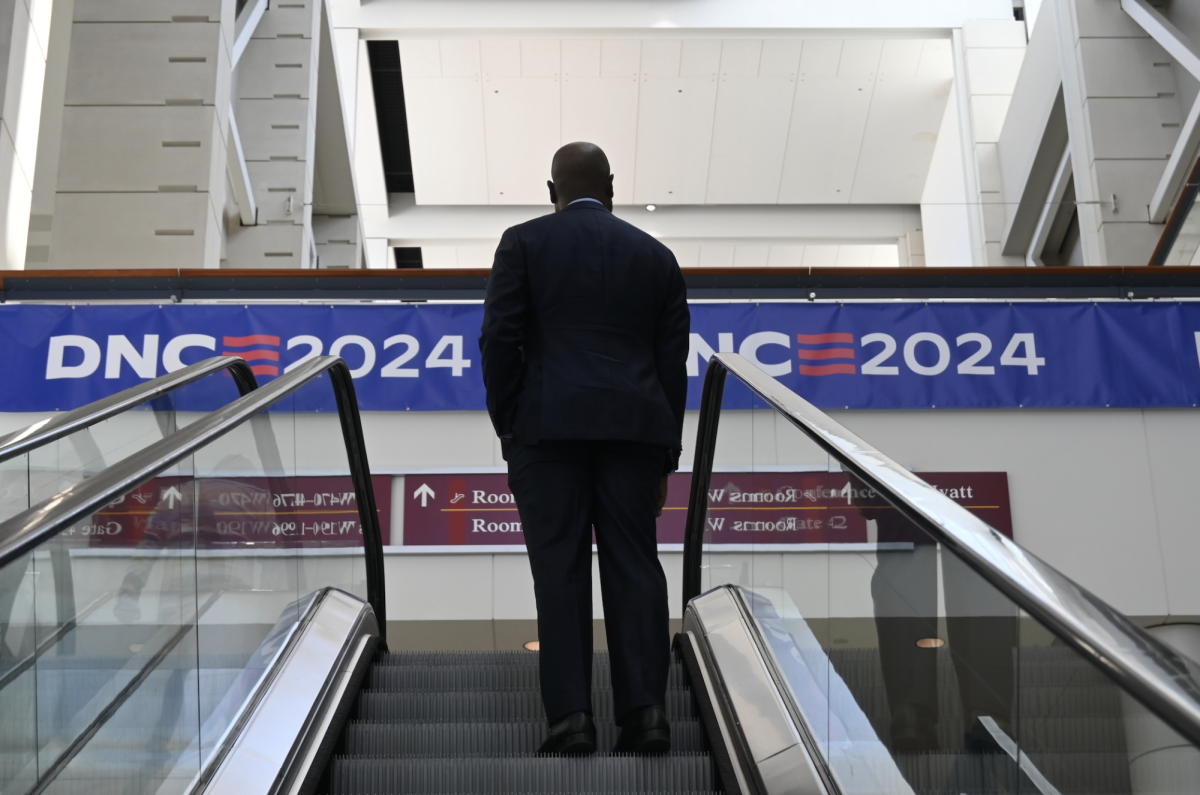 An attendee rides the escalator to the floor of the Democratic National Convention at the United Center on Monday, Aug. 19.