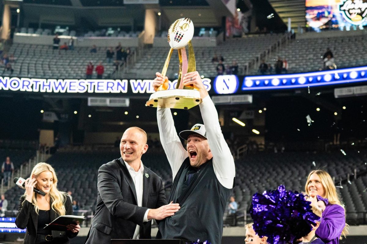 Coach David Braun hoists the 2023 Las Vegas Bowl trophy.