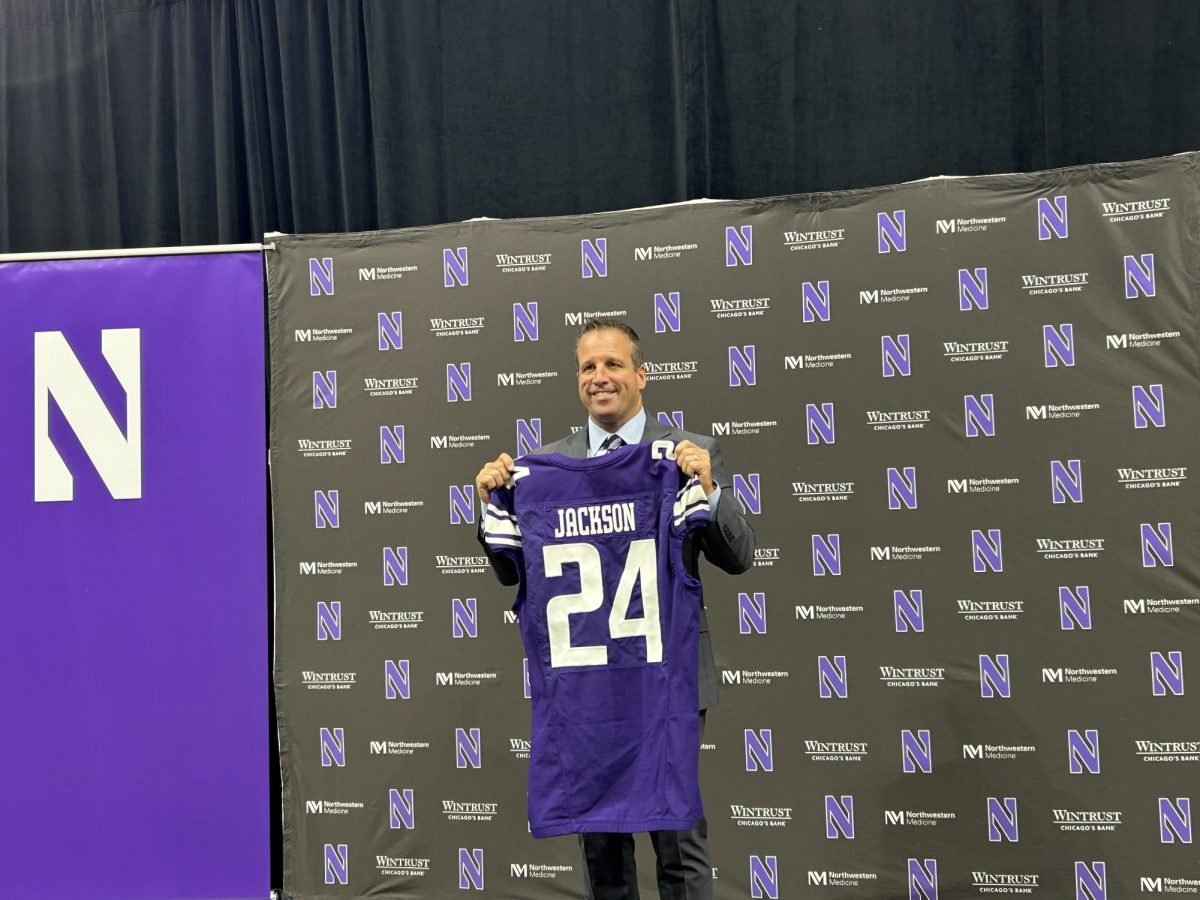 Northwestern athletic director Mark Jackson holds up an honorary No. 24 jersey during his introductory press conference on Tuesday.