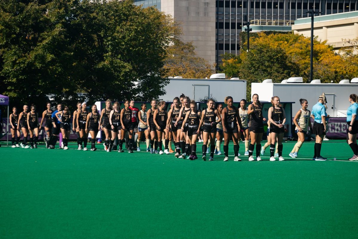 The Northwestern and UC Davis squads walk onto the field prior to the national anthem.