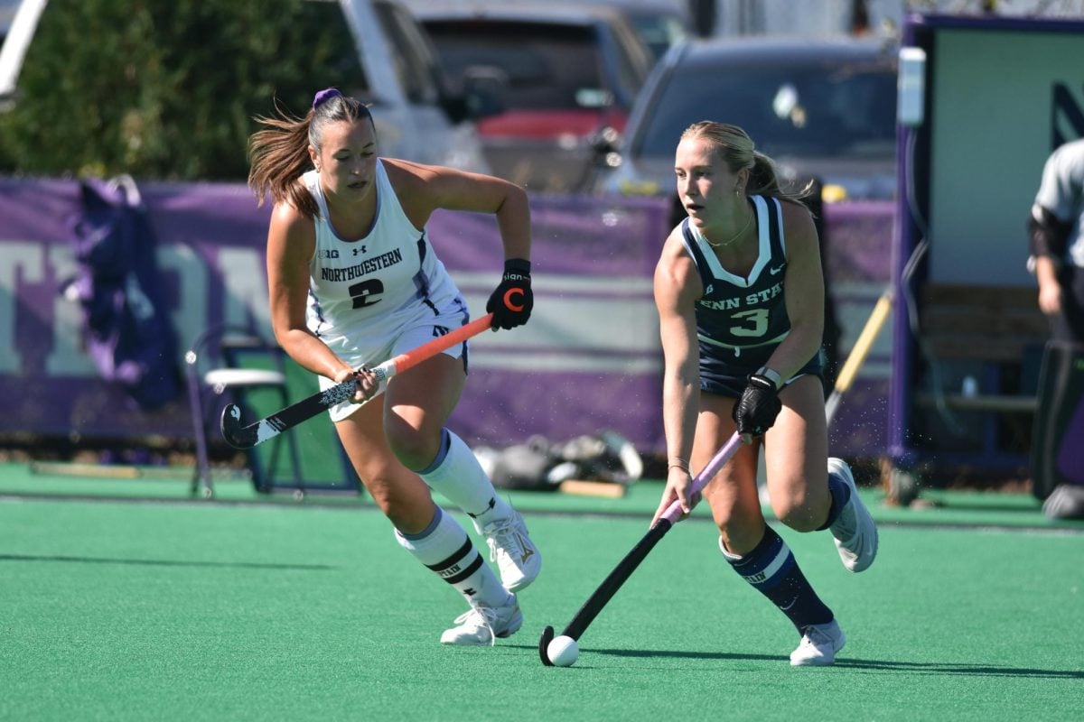 A player follows closely behind another player who has the ball.