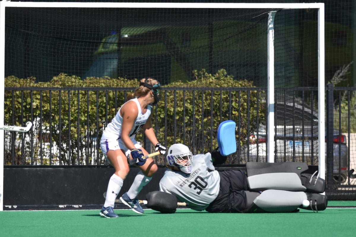 Sliding to the right of the net, the Northwestern goalie blocks an attempted shot with her legs.