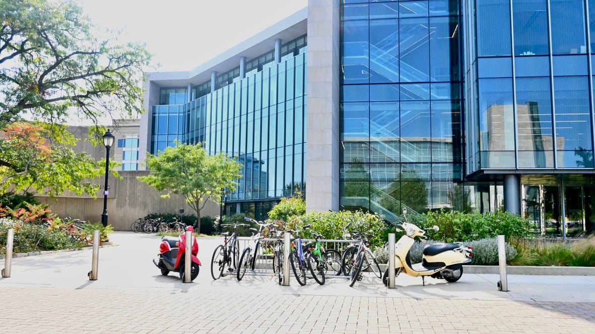 Bikes and mopeds parked outside a building.