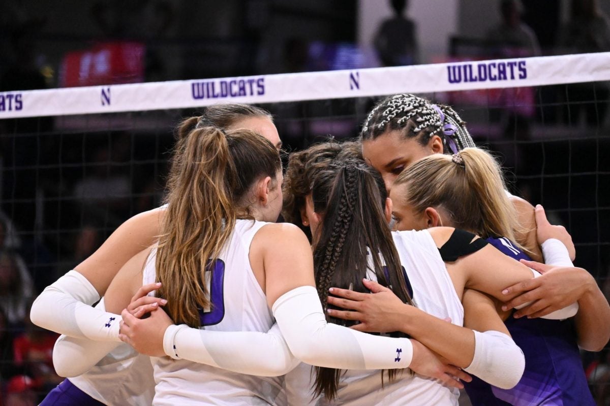 Northwestern huddles on the court. The ’Cats fell in three sets to No. 10 Purdue Friday. 