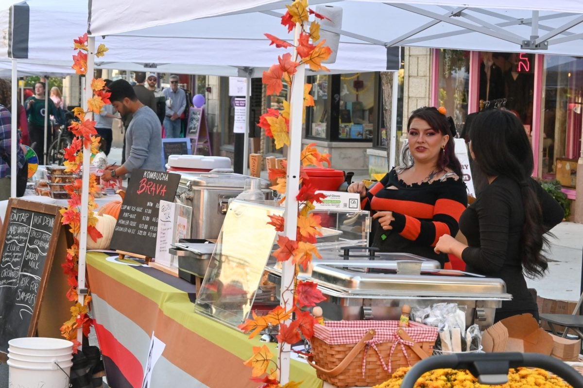 The owners of Kombucha Brava talk next to their booth on Main Street. 
