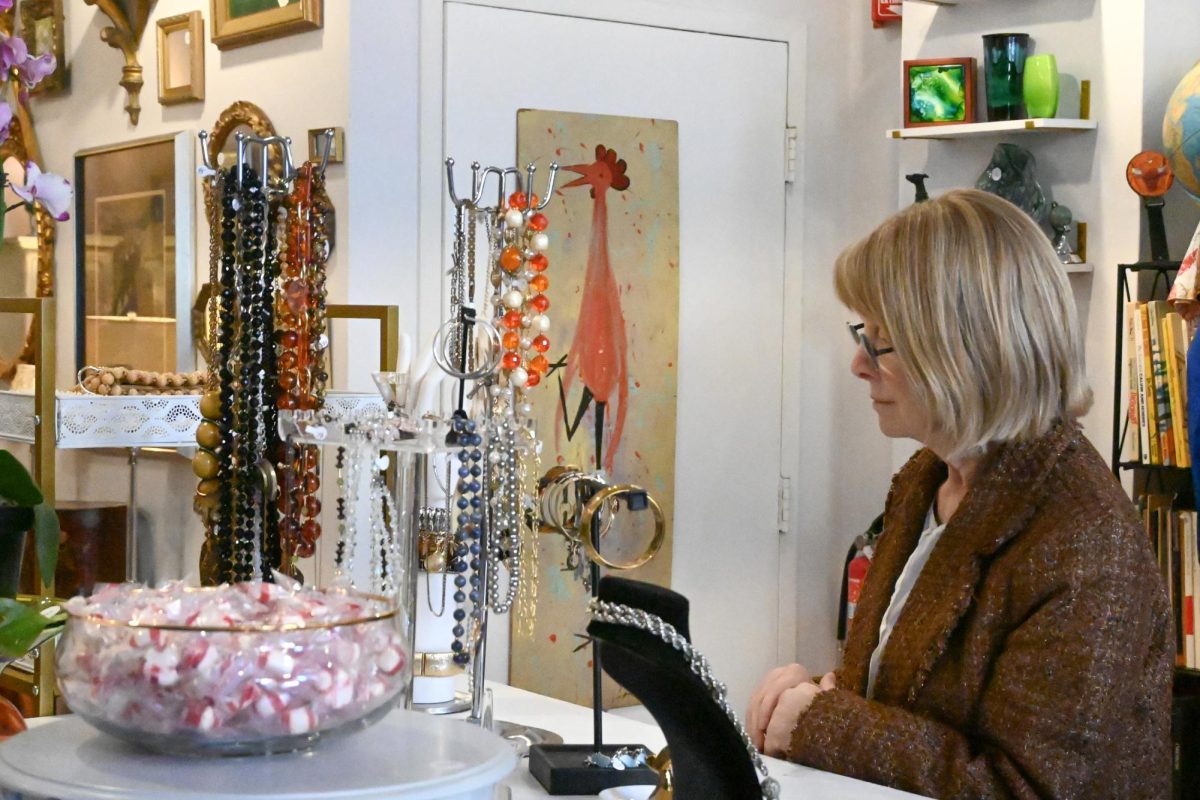  A festival attendee admires a display of jewelry in The Vintage Cat, a new consignment shop on Main Street. 