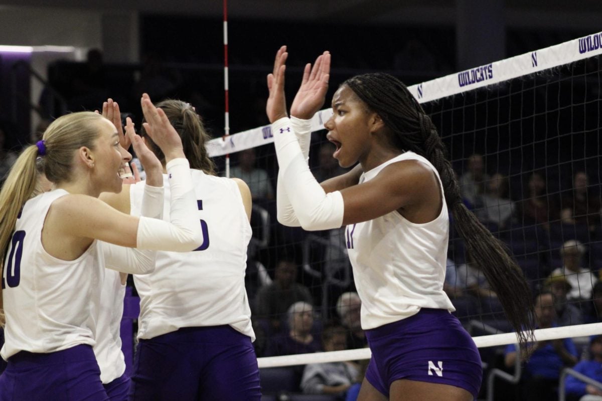 Junior middle blocker Kennedy Hill high-fives a teammate.