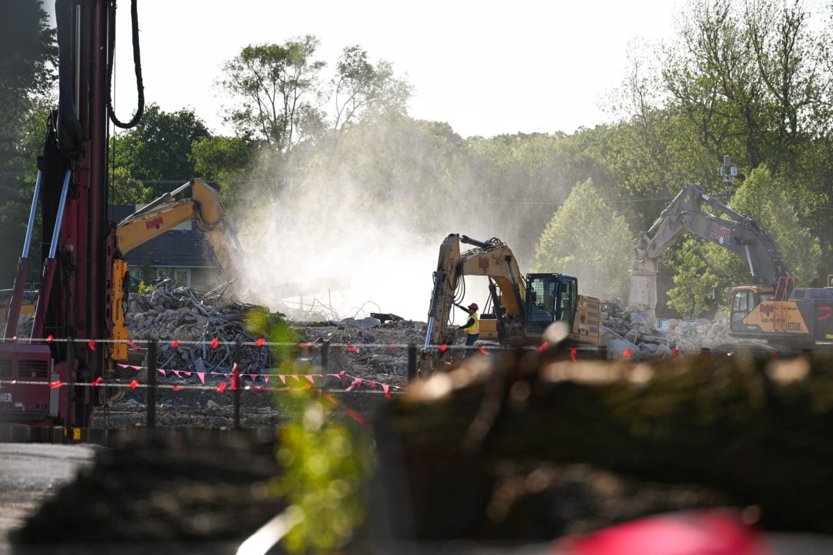 Dusty cars parked on road next to Ryan Field construction